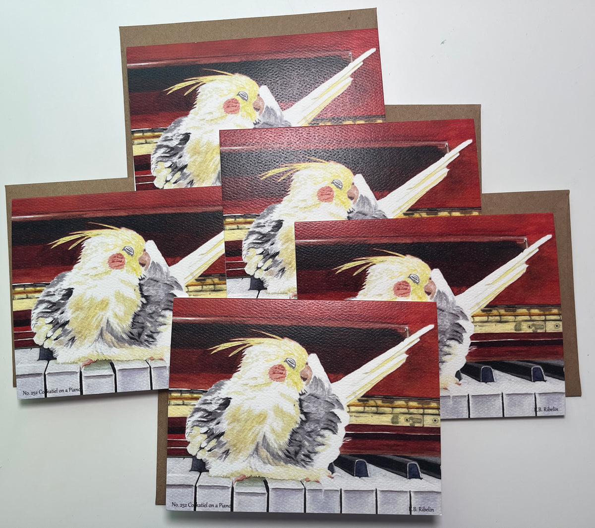 Notecard set featuring the cockatiel perched on a piano artwork.