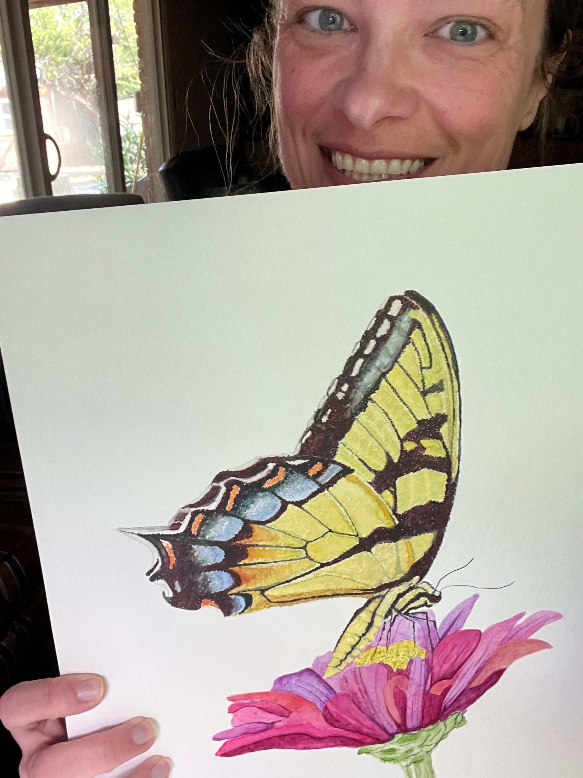 Artist holding the original painting of a eastern tiger swallowtail butterfly with yellow and black patterned wings, showing the artwork clearly.