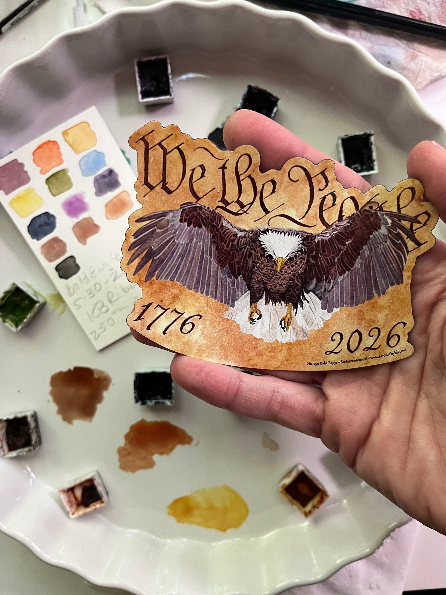bald eagle flying forward over parchment background with “we the people” lettering