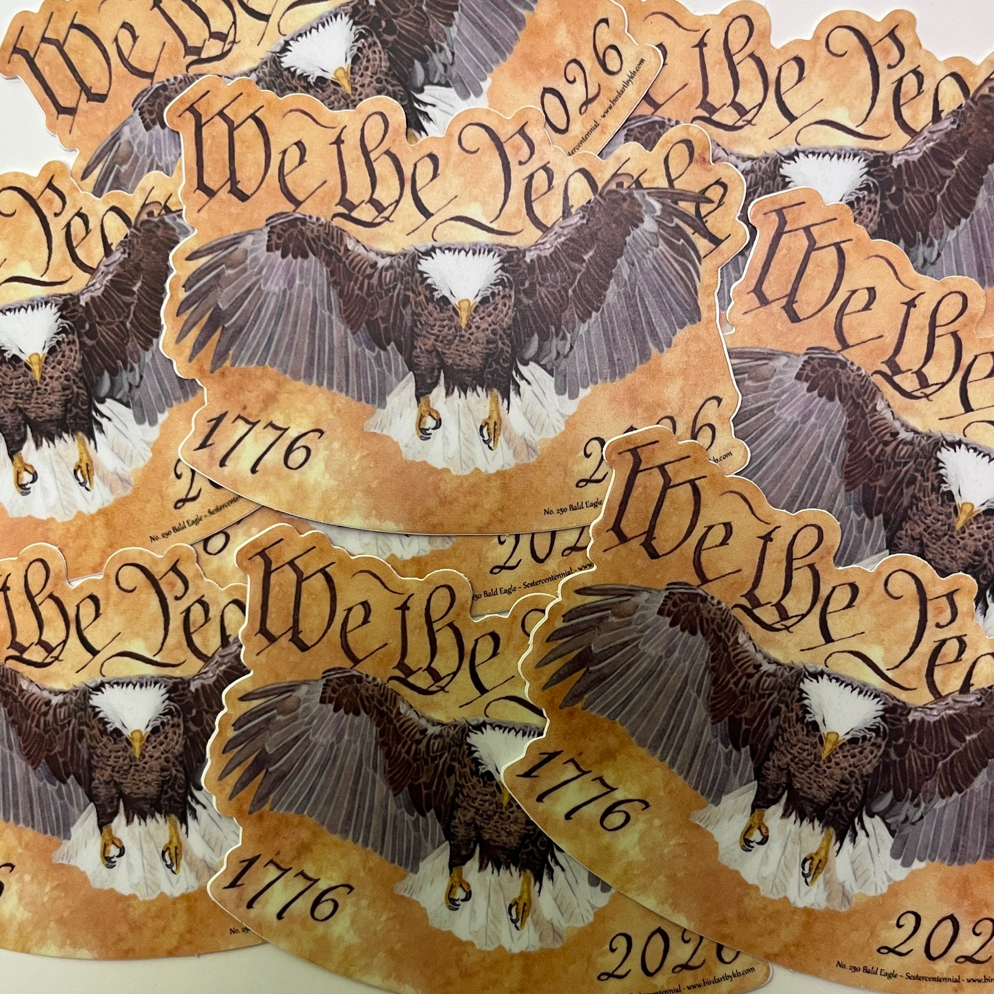 bald eagle flying forward over parchment background with “we the people” lettering