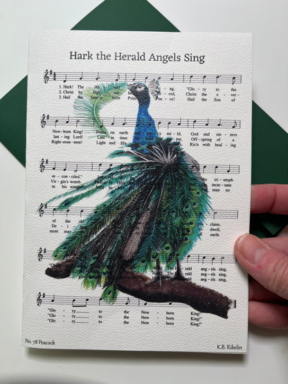 Christmas 2026 notecard featuring Hark the Herald Angels Sing with festive peacock artwork by KB.