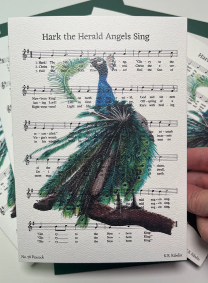Christmas 2026 notecard featuring Hark the Herald Angels Sing with festive peacock artwork by KB.