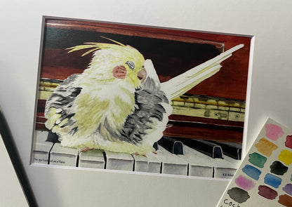 Giclee print of a cockatiel perched on a piano displayed in a white mat.