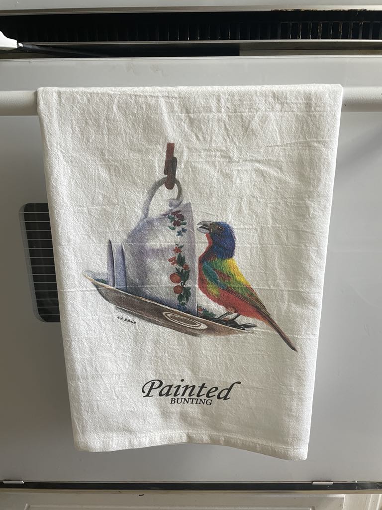 Tea towel printed with the painted bunting on a floral teacup artwork.