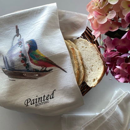 Tea towel printed with the painted bunting on a floral teacup artwork.