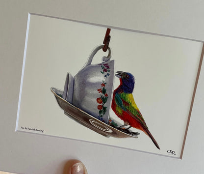 Giclée print of a painted bunting perched on a floral teacup displayed in a white mat.